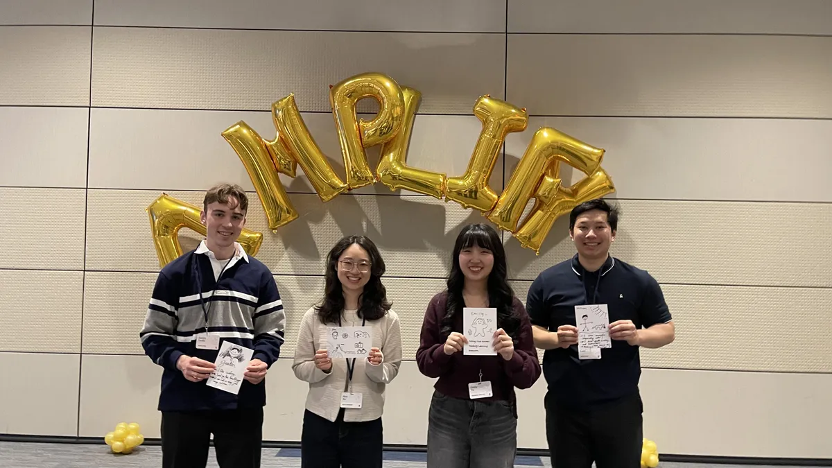 My team holding up drawing of ourselves and interests during the first week of orientation